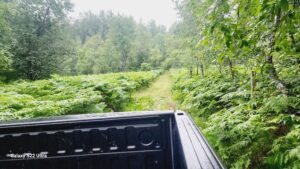 truck driving on back road in middle of land in michigan